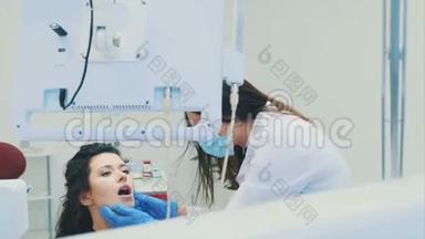 <strong>牙医</strong>和病人。 年轻漂亮的<strong>牙医</strong>在<strong>牙医</strong>`办公室修理一位漂亮年轻女子的牙齿。 <strong>牙医</strong>